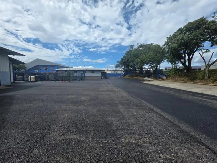 Acabado final de asfaltado y pavimentación en parqueo y predio industrial.