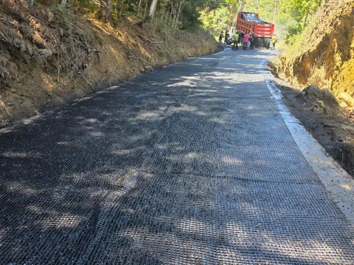 Colocación de geomalla de refuerzo en vía rural previo al vertido y extendido de mezcla asfáltica.