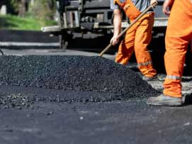 Imagen de hombres trabajando con mezcla asfáltica